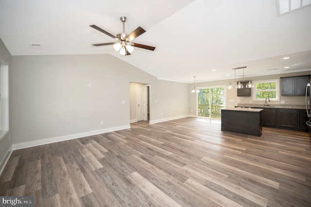 unfurnished living room with wood-type flooring, sink, lofted ceiling, and ceiling fan