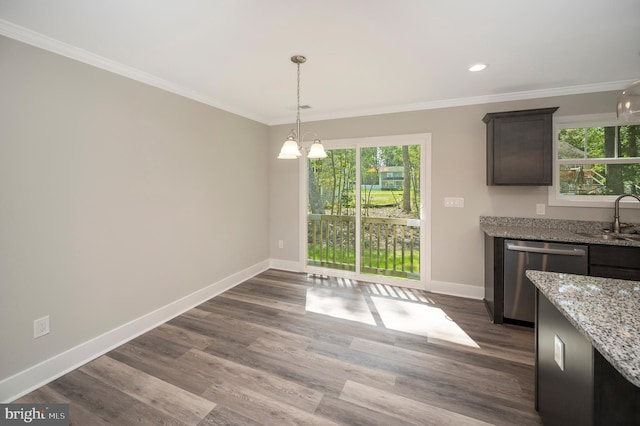 unfurnished dining area with ornamental molding, dark wood-type flooring, sink, and an inviting chandelier