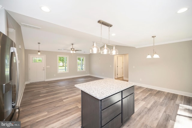 kitchen featuring light hardwood / wood-style floors, decorative light fixtures, and stainless steel fridge