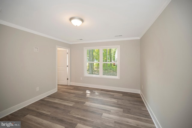 spare room with dark wood-type flooring and ornamental molding