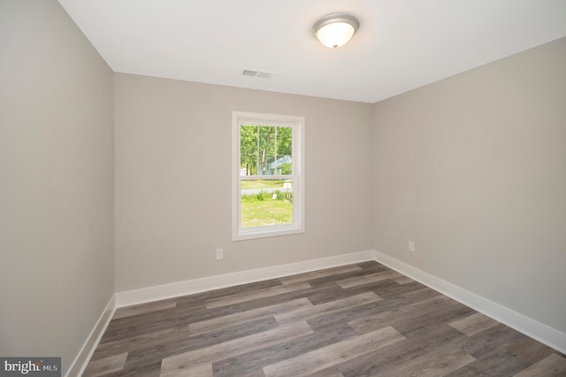 unfurnished room with dark wood-type flooring