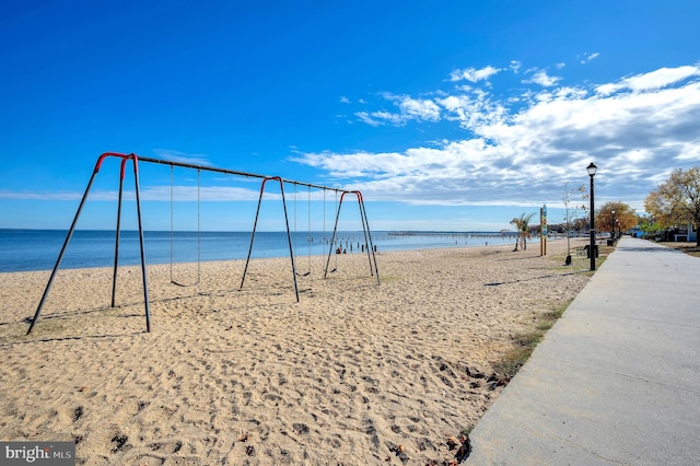 view of property's community featuring a beach view and a water view