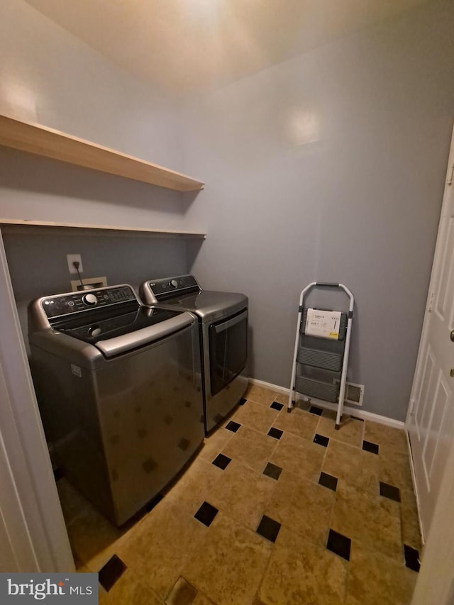 laundry room featuring independent washer and dryer and light tile patterned floors