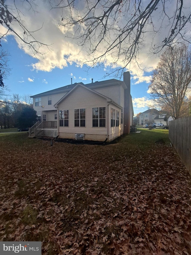 back of house with a wooden deck and a yard