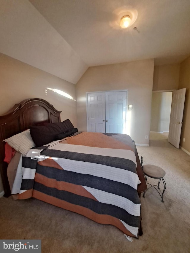 carpeted bedroom featuring a closet and lofted ceiling