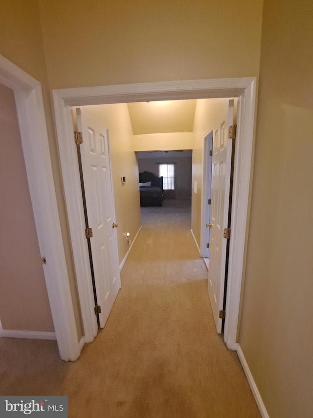 corridor featuring light colored carpet