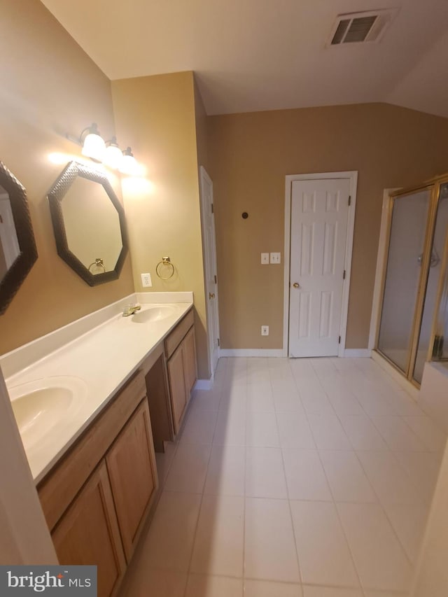 bathroom with tile patterned flooring, vanity, lofted ceiling, and walk in shower