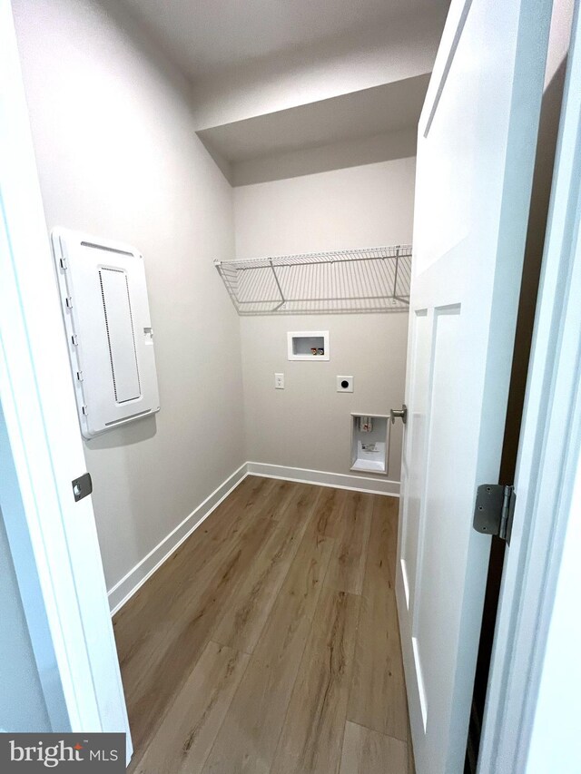 laundry area with electric panel, washer hookup, hookup for an electric dryer, and light hardwood / wood-style flooring