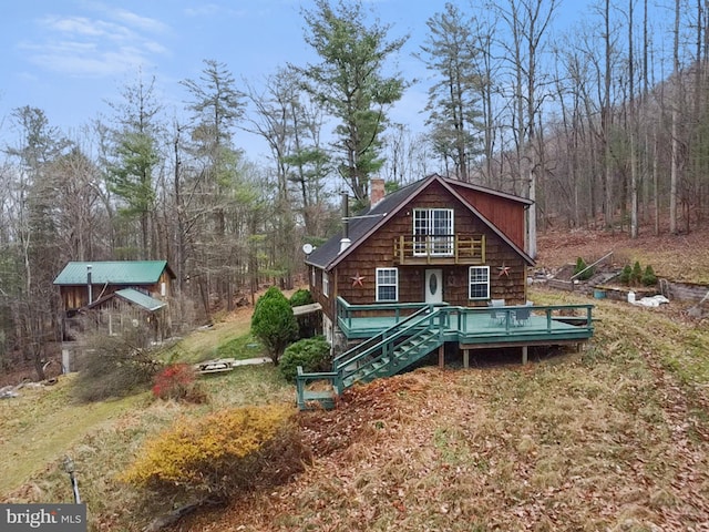 rear view of house with a lawn and a deck