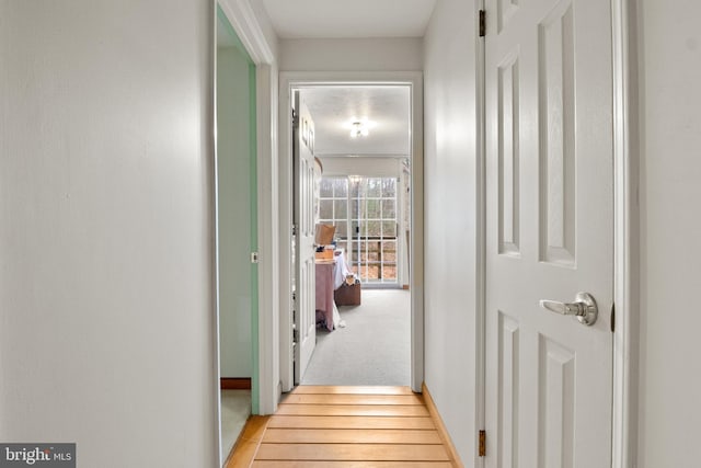 corridor with light hardwood / wood-style floors