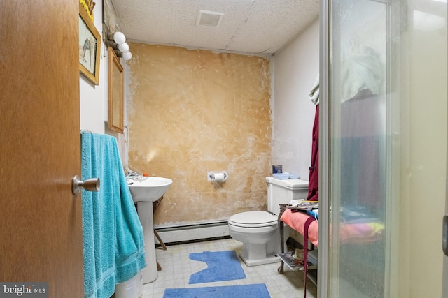 bathroom with toilet, a shower, and a baseboard radiator