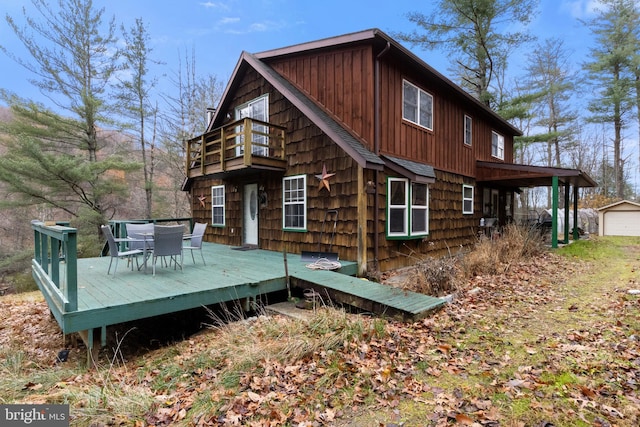 back of house with a wooden deck and a balcony