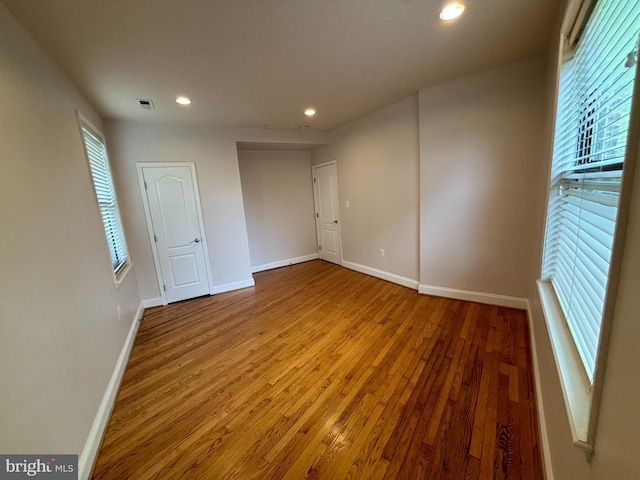 unfurnished room featuring a wealth of natural light and wood-type flooring