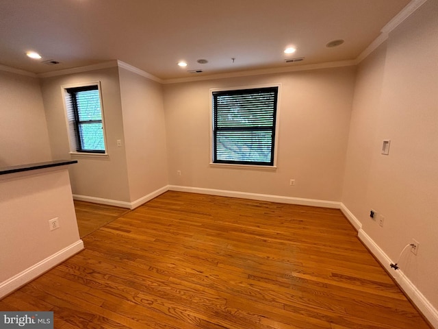 unfurnished room featuring wood-type flooring and ornamental molding