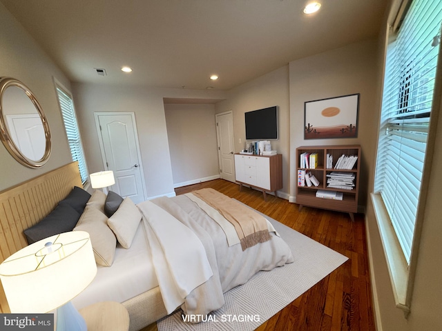 bedroom featuring dark hardwood / wood-style flooring and multiple windows