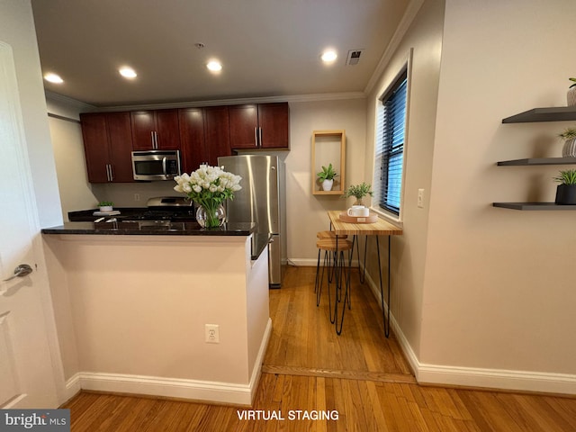 kitchen with crown molding, stainless steel appliances, a kitchen breakfast bar, light hardwood / wood-style floors, and kitchen peninsula