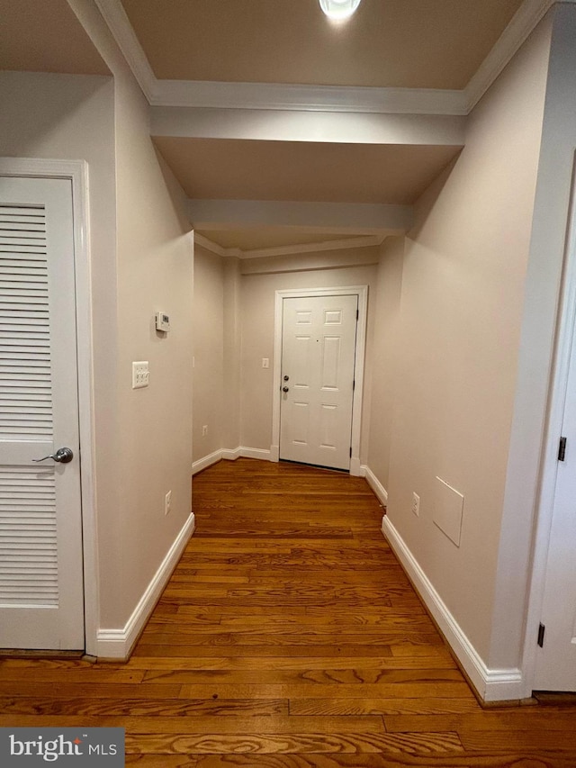 hallway with hardwood / wood-style floors and ornamental molding