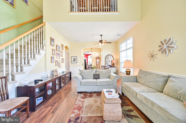 living room featuring hardwood / wood-style floors, a high ceiling, and ceiling fan