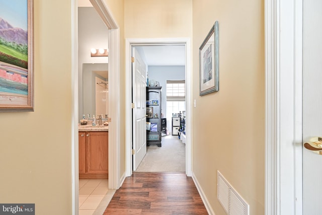 hall with wood-type flooring and sink