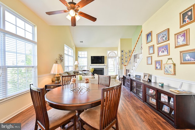 dining space with dark wood-type flooring, vaulted ceiling, and ceiling fan