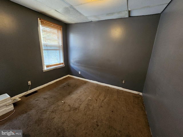 spare room featuring a drop ceiling and carpet floors