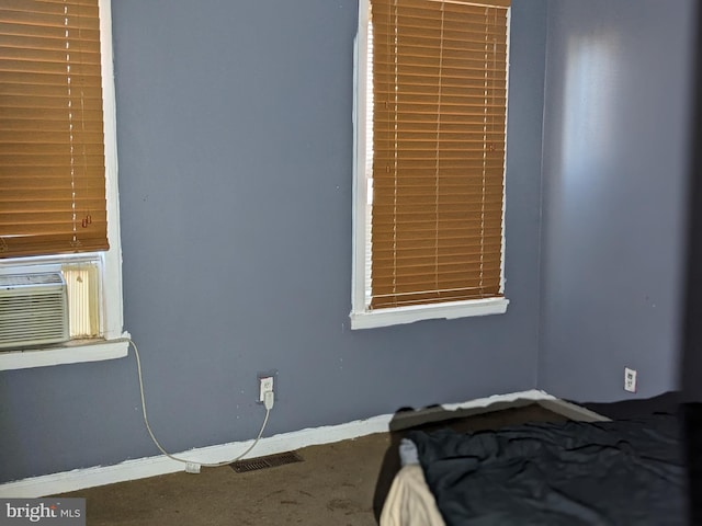 unfurnished bedroom featuring cooling unit and carpet floors