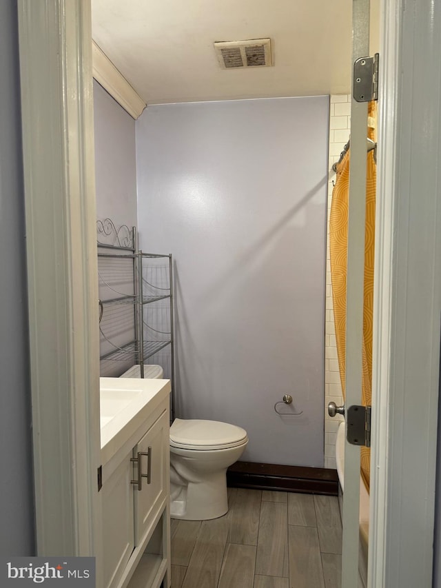 bathroom with hardwood / wood-style floors, vanity, and toilet