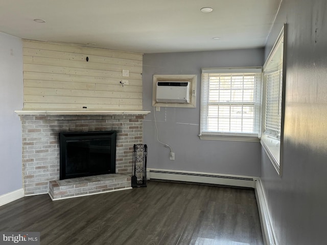 unfurnished living room featuring an AC wall unit, a brick fireplace, dark hardwood / wood-style floors, and a baseboard heating unit