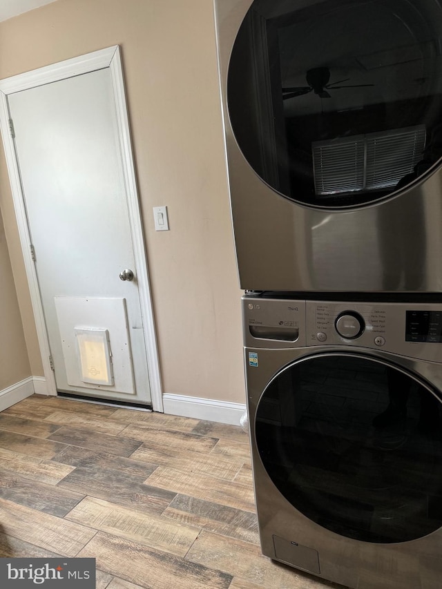 washroom with light hardwood / wood-style floors and stacked washer and clothes dryer