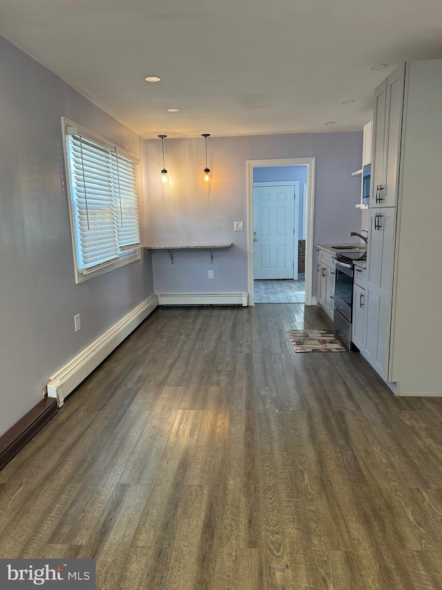 unfurnished living room with dark hardwood / wood-style flooring, a baseboard radiator, and sink