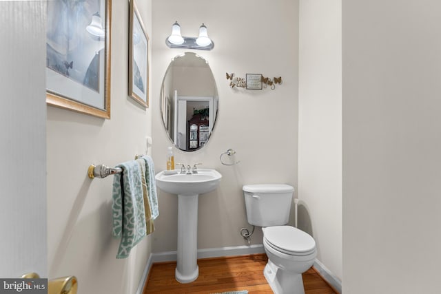 bathroom featuring hardwood / wood-style flooring, toilet, and sink