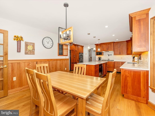 4414 Mountville Rd, Frederick, MD 21703 - dining space featuring light wood-style floors, wainscoting, beverage cooler, a chandelier, and wooden walls