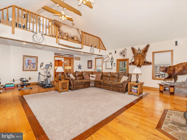 living room with hardwood / wood-style floors, high vaulted ceiling, and ceiling fan