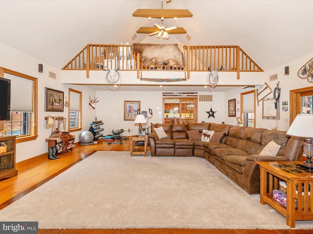 living room featuring hardwood / wood-style flooring, high vaulted ceiling, and ceiling fan