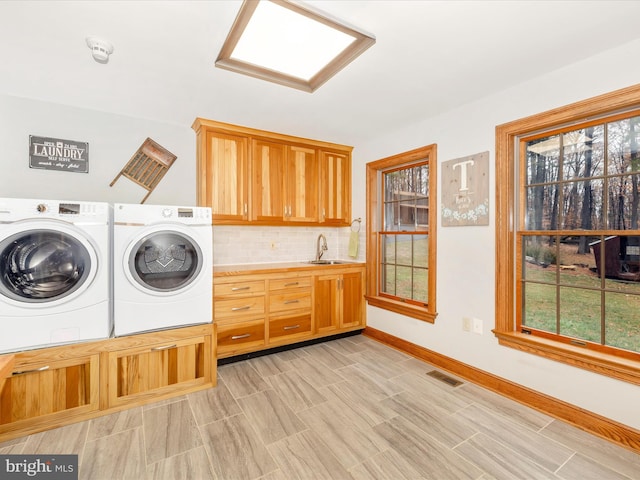 washroom with sink, cabinets, and independent washer and dryer