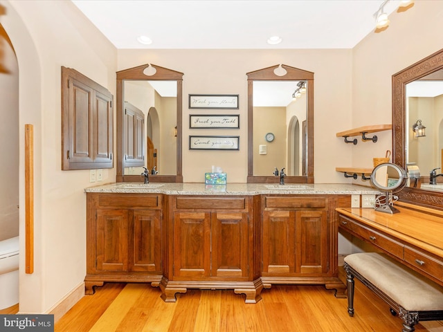 bathroom with toilet, vanity, and hardwood / wood-style flooring