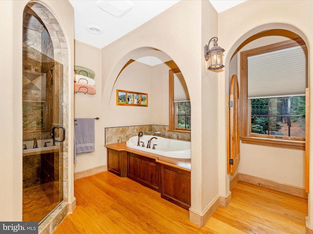 bathroom with separate shower and tub and hardwood / wood-style flooring