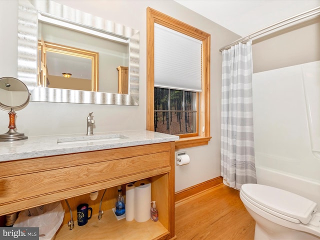 full bathroom with wood-type flooring, vanity, toilet, and shower / tub combo with curtain