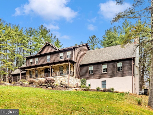 back of property featuring a lawn and covered porch