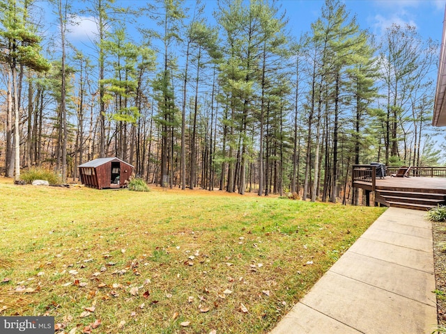 view of yard with a wooden deck and a storage unit