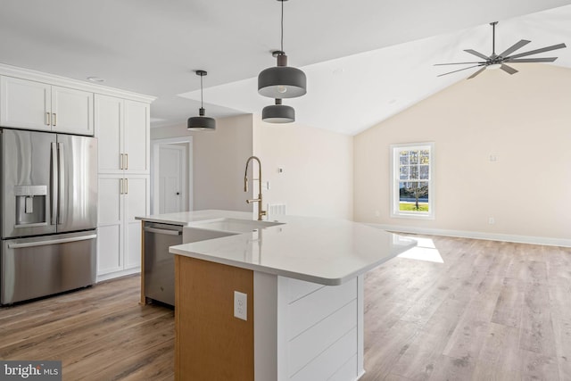 kitchen with white cabinetry, a kitchen island with sink, lofted ceiling, and appliances with stainless steel finishes