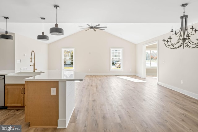 kitchen with decorative light fixtures, a healthy amount of sunlight, sink, and light hardwood / wood-style flooring