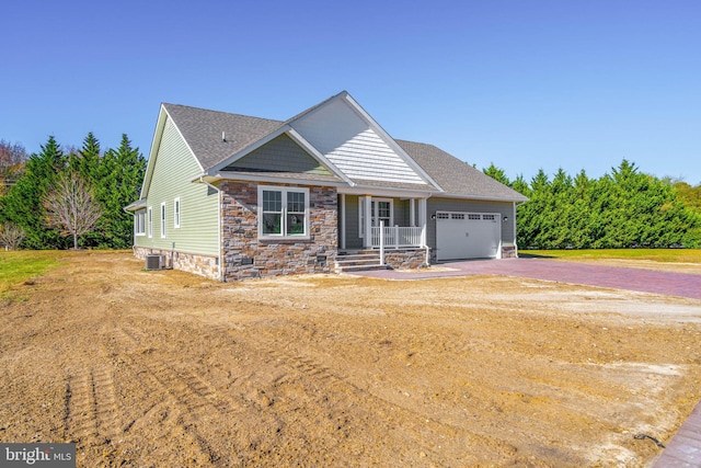 craftsman house featuring covered porch, a garage, and central AC