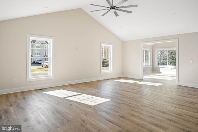 unfurnished living room with ceiling fan, wood-type flooring, and high vaulted ceiling