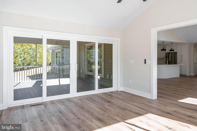 entryway featuring wood-type flooring, vaulted ceiling, and ceiling fan