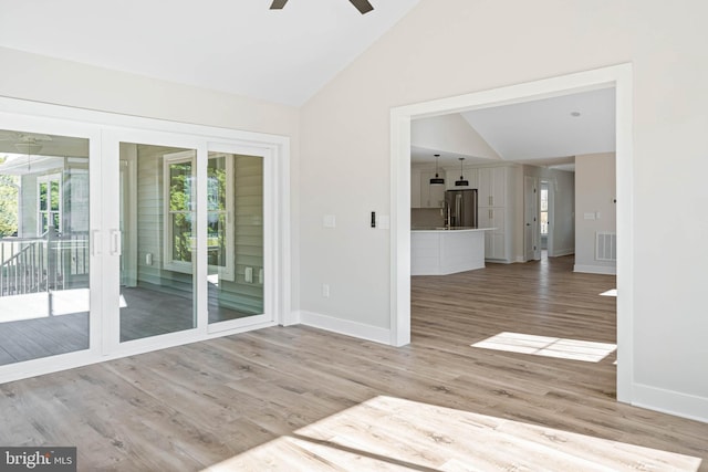 spare room featuring hardwood / wood-style flooring, ceiling fan, and lofted ceiling