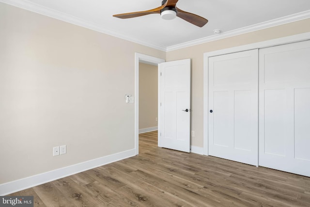 unfurnished bedroom featuring a closet, ceiling fan, crown molding, and wood-type flooring