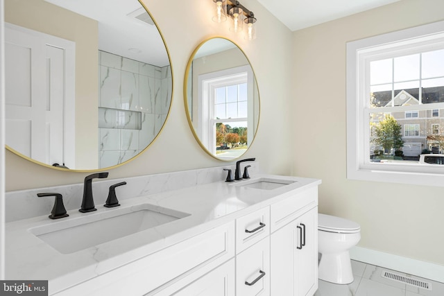 bathroom with toilet, vanity, tile patterned floors, and a healthy amount of sunlight