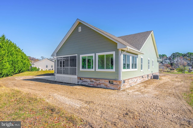 rear view of house with cooling unit and a sunroom