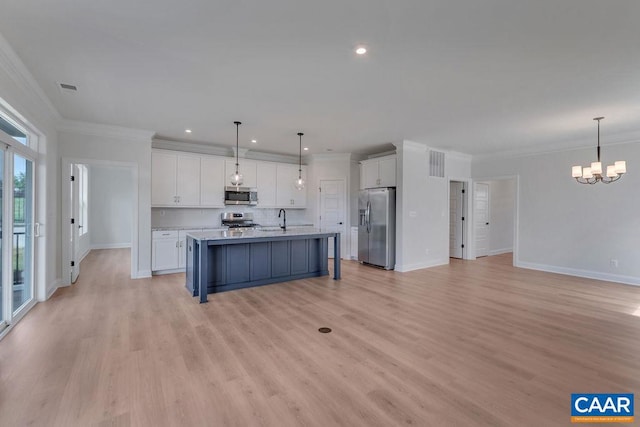 kitchen with sink, appliances with stainless steel finishes, light hardwood / wood-style flooring, white cabinets, and pendant lighting